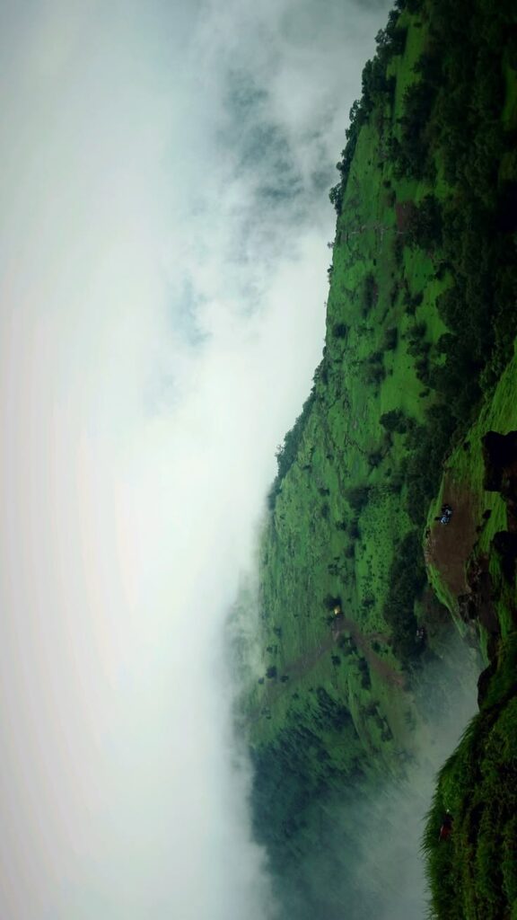 Matheran hill station with lush green mountains, misty clouds, and scenic monsoon valley views
