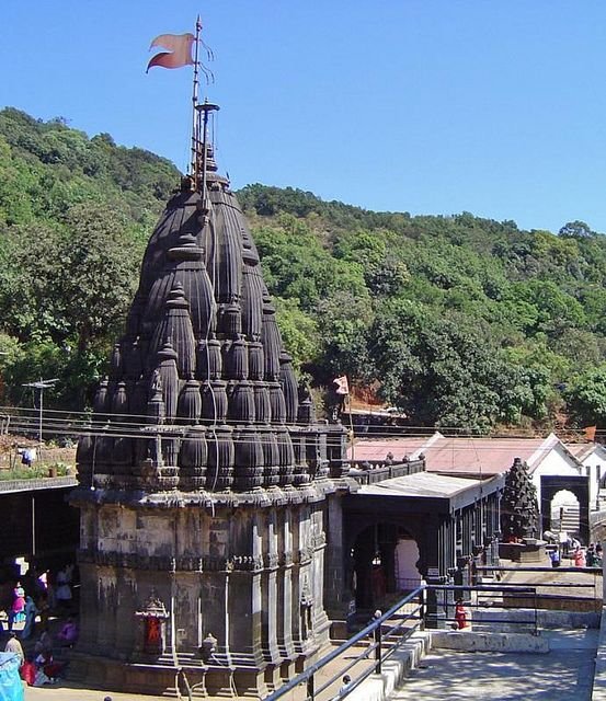 Mumbai to Bhimashankar cab service with BudgetCab Service vehicle near Bhimashankar Temple and scenic Sahyadri hills.